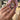 Hand wearing a ring with a pink gemstone and cz accents