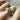 Silver ring with green gemstones on a finger