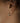 Close-up of an ear with heart-shaped earrings on a neutral background