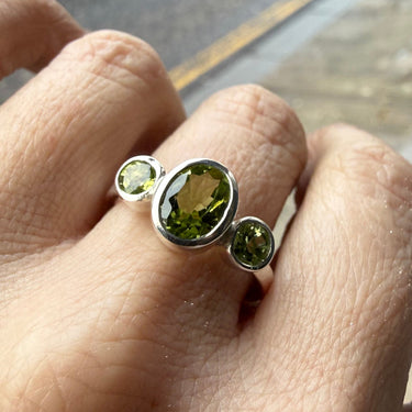 skinny wrists Silver ring with green peridot gemstones on a finger