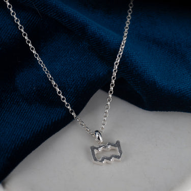 skinny wrists Aquarius Silver necklace with a pendant on a blue fabric background